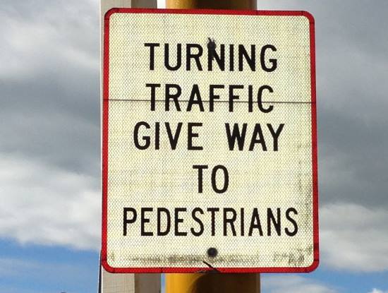 turning traffic must give way to pedestrians sign