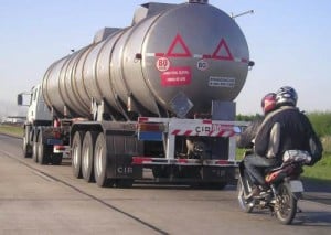 This rider and pillion passenger is travelling so close that there's no way to see what's happening in front of the truck