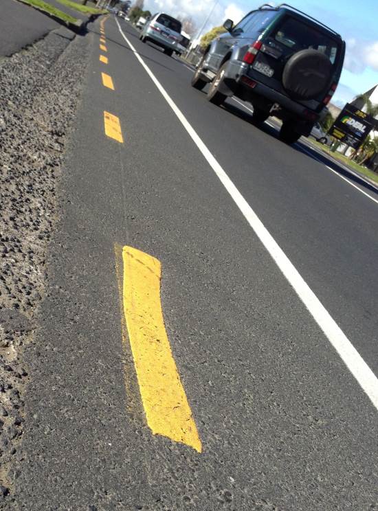 broken yellow line on the side of the road