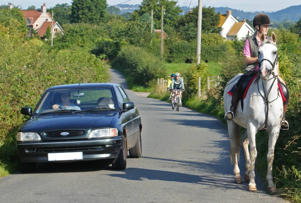 car overtaking a horse and rider safely