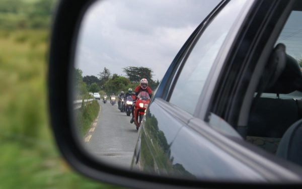 motorbike convoy reflected in car wing mirror