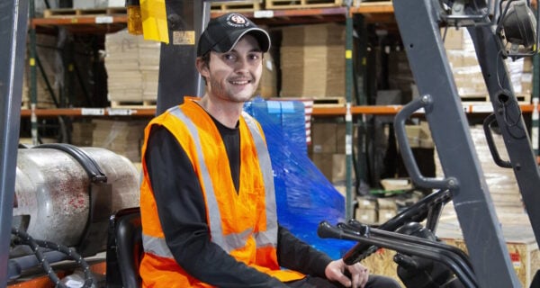 Forklift operator wearing a baseball cap