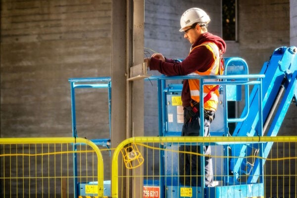 Man working on boom lift, with barriers surrounding the work site